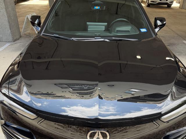 Hood of the Acura ZDX after paint hydration, with clouds and sky reflecting clearly in the black finish