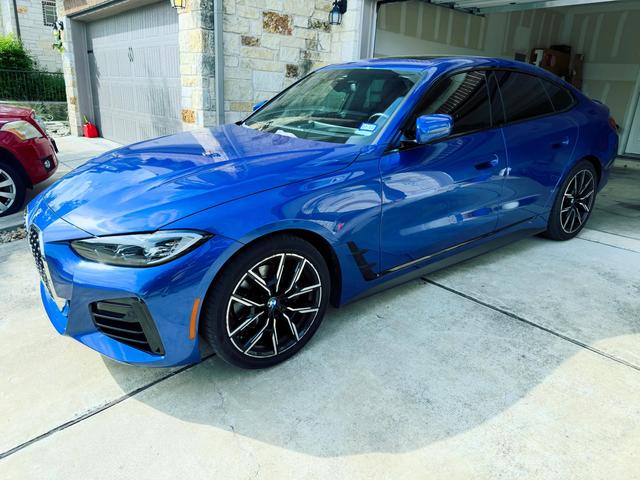 Bright blue 2024 BMW 430i after a Gold detail, parked in a driveway with glossy paint and two-tone wheels