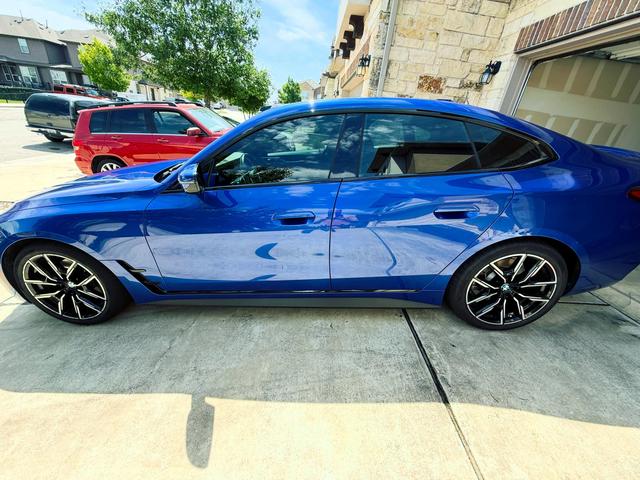 Side profile of the blue BMW 430i after the detail, with deep reflections running along the doors and fenders