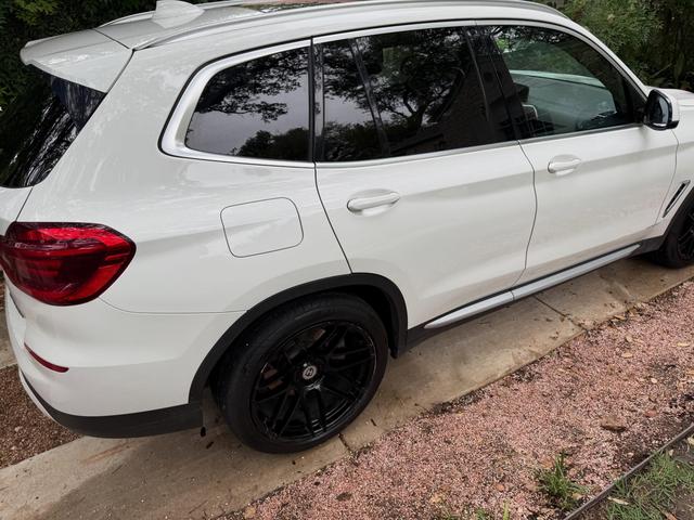 White 2020 BMW X3 from the rear passenger side after a hand wash, with glossy paint and clean black alloy wheels