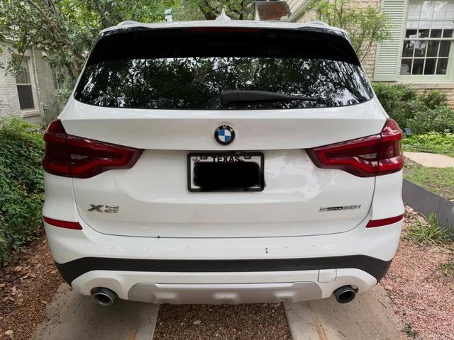 Rear of the white BMW X3 after a hand wash, with clean taillights and a bright, glossy tailgate