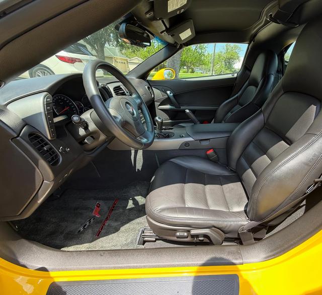 Driver-side view into the Corvette after cleaning, with the leather bucket seat, steering wheel, and carpet fresh
