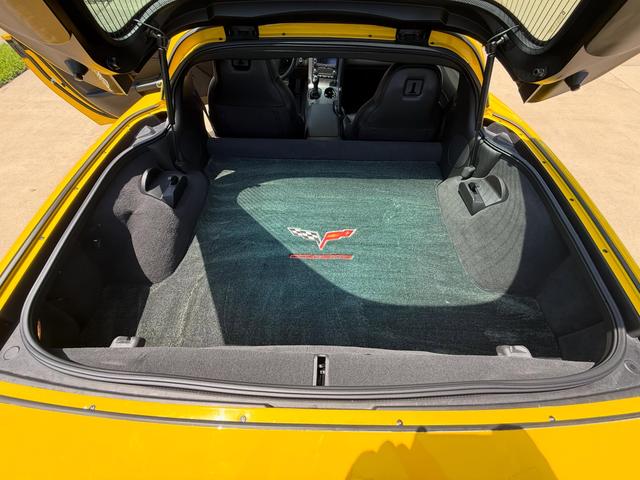 Corvette rear cargo area with the hatch open, showing a clean, vacuumed cargo mat and trim