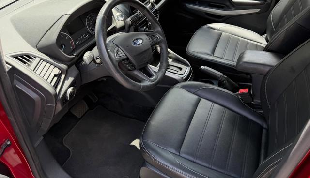 After: the EcoSport driver seat and footwell with clean black carpet and wiped-down leather