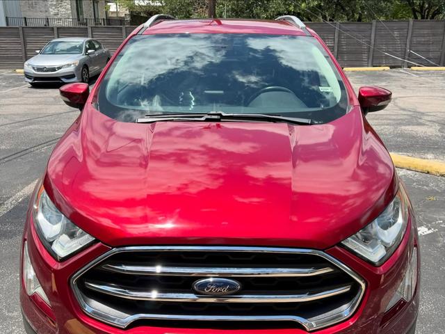 Front of the red EcoSport with clouds reflecting in the freshly washed hood and a spotless chrome grille