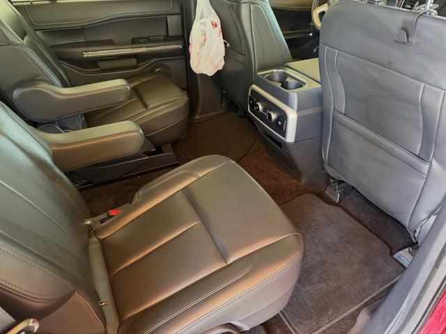 Second-row captain's chairs of the red Ford Expedition after the interior detail, with clean leather and carpet