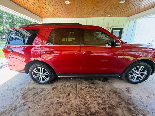 Side profile of the red Ford Expedition in the carport shade with deep, even gloss