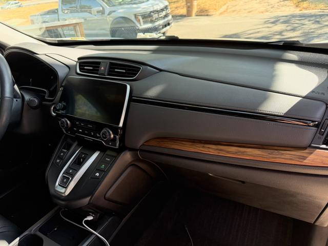 Honda CR-V dashboard after cleaning, showing a dust-free touchscreen, center vents, and wood-grain dash trim