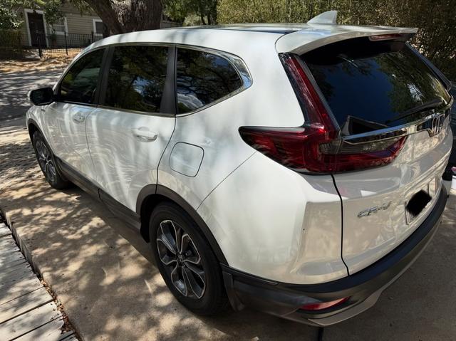 Rear three-quarter view of the white CR-V Hybrid after the wash, showing clean taillights, glass, and lower trim