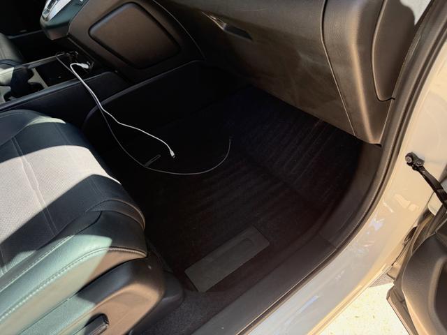 Passenger footwell of the CR-V Hybrid after a deep vacuum, with a clean black floor mat and wiped seat base