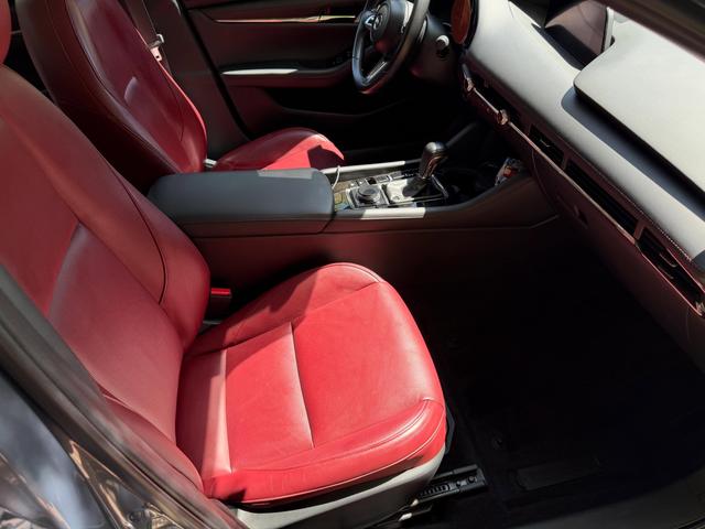 Passenger side of the Mazda 3 cabin after cleaning, with red leather seats and a wiped-down center console
