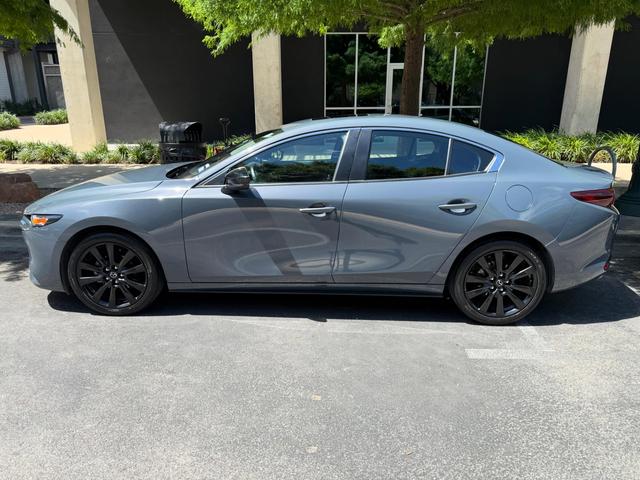 Gray Mazda 3 Carbon Edition after a Silver detail in Austin, parked in side profile with black wheels