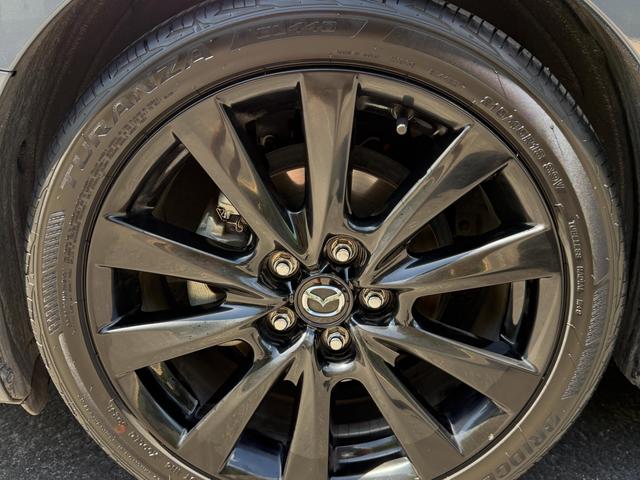 Close-up of a gloss black Mazda 3 Carbon Edition wheel after cleaning, with a dressed tire and no brake dust