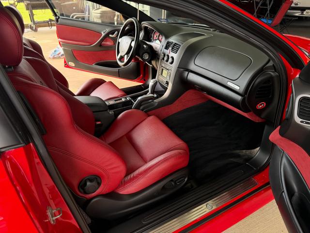 Passenger-side red leather bucket seat of the GTO after the detail, with a wiped-down dash and clean sill plate