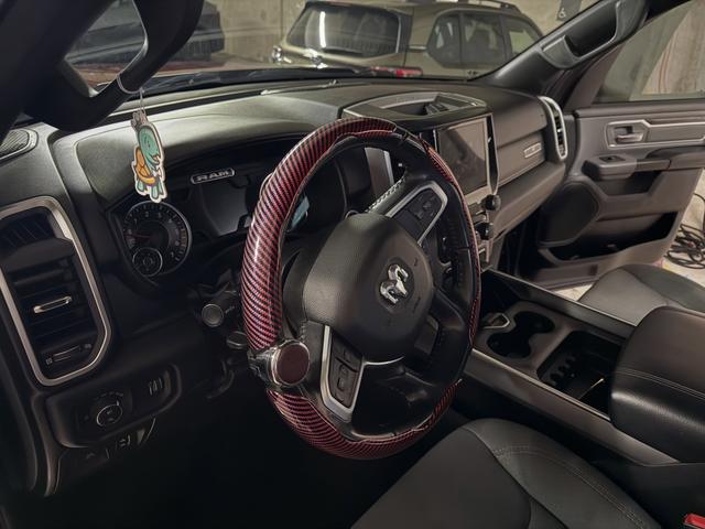 Driver cockpit of the red Ram 1500 after cleaning, with a red carbon-look steering wheel cover and wiped-down gauges