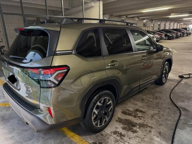 Rear quarter of the green Subaru Forester after the detail, with clean taillights and two-tone alloy wheels