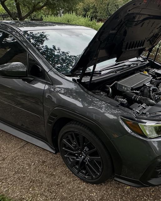 Subaru WRX with its hood propped open during the detail, front fender and wheel freshly washed