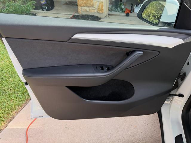 Clean driver door panel of the white Tesla Model Y after the detail