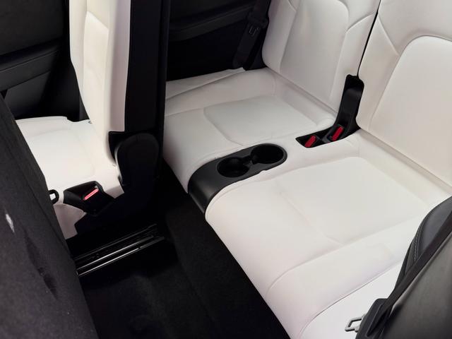 Close view of the Model Y rear bench and fold-down cupholders after the interior detail, white leather left clean