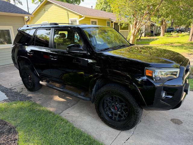 Toyota 4Runner from the passenger-side front corner, showing clean black paint, tinted glass, and freshly dressed tires