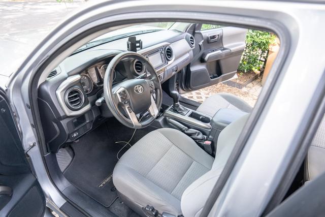 Clean front cabin of the silver Toyota Tacoma seen through the driver door