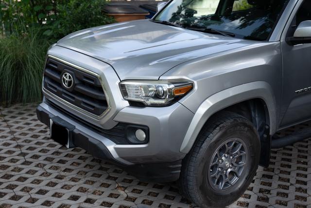 Close view of the Tacoma front end after washing, with a clean grille, headlight, and bright silver hood