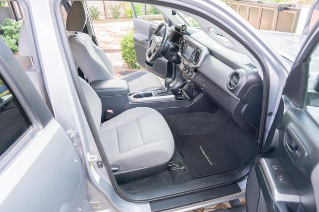 Passenger seat and floor of the Tacoma after vacuuming, with clean cloth upholstery and floor mat