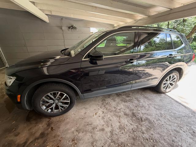 Dark Volkswagen Tiguan after a Silver mobile detail in Austin, parked under a carport with glossy paint